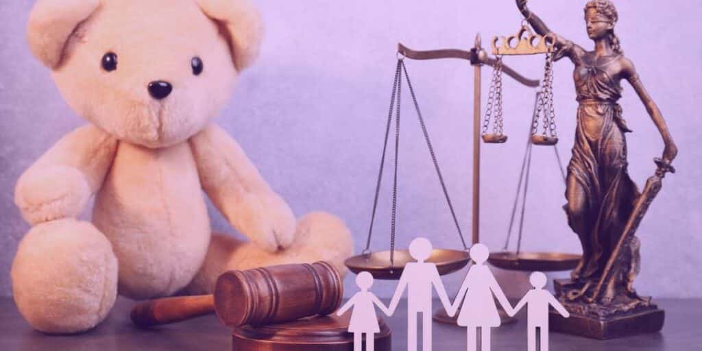 Um ursinho, um martelo, uma família, uma balança da justiça e a estátua da justiça representando a guarda alternada.